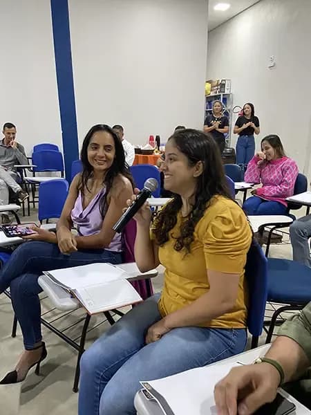 Duas participantes sentadas em uma palestra da ASAC