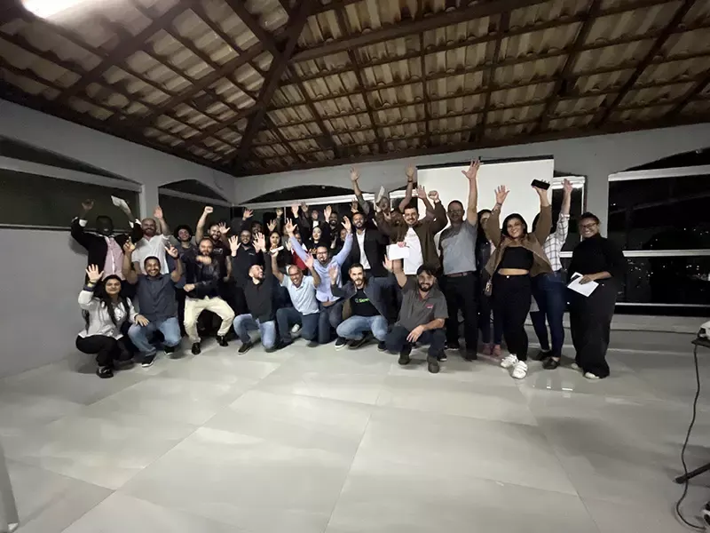 Grupo de participantes com os braços erguidos ao final de um evento da ASAC